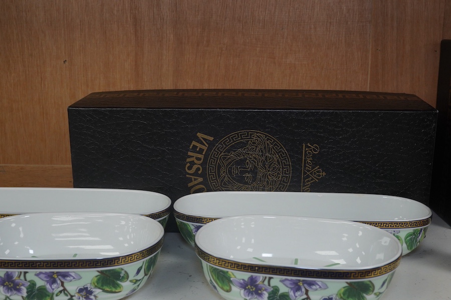 Six Rosenthal for Versace porcelain items; a boxed chocolate cup and saucer, four oblong serving dishes, longest 23cm, and a boxed miniature timepiece, 8.5cm high. Condition - good.